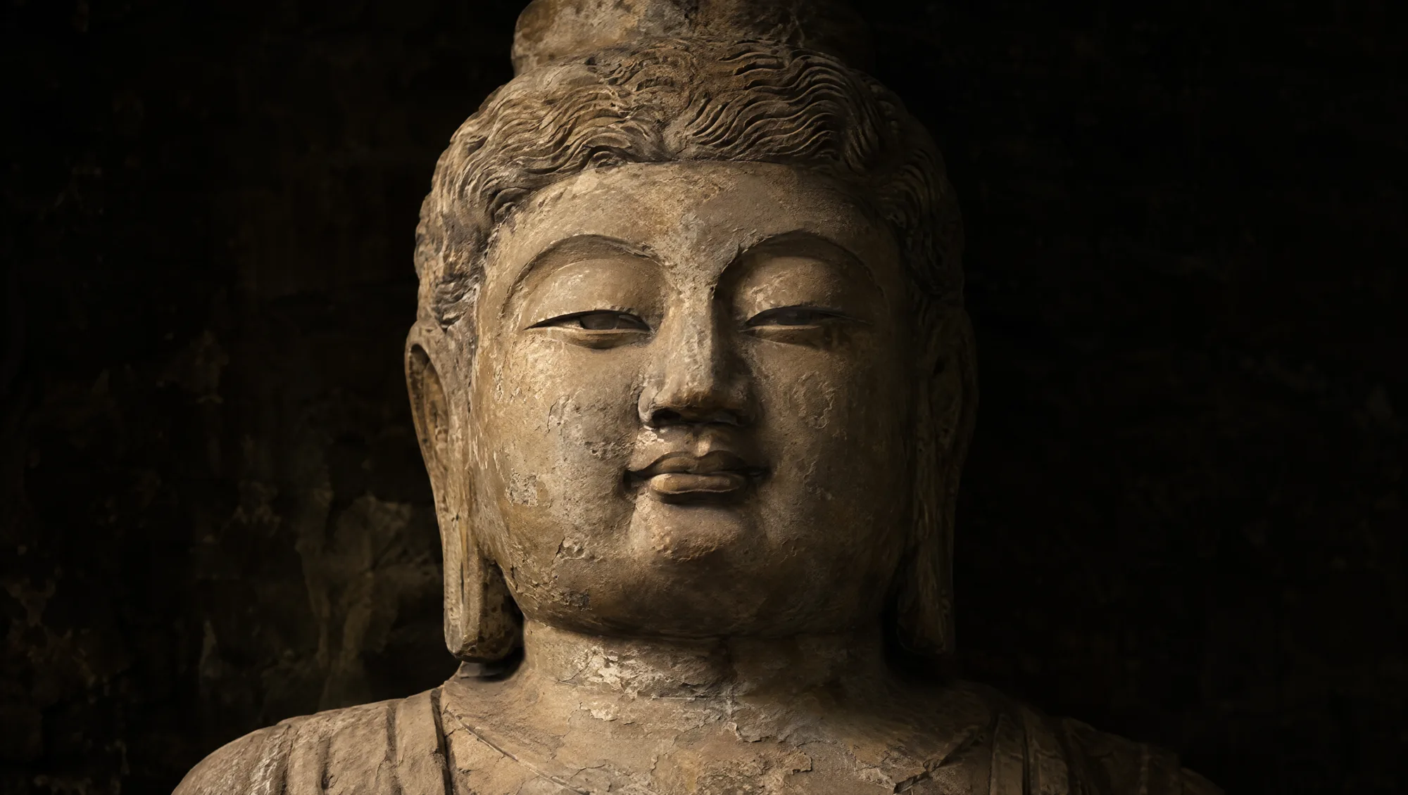 The Longmen cliff-carved Vairocana Buddha face in tan limestone