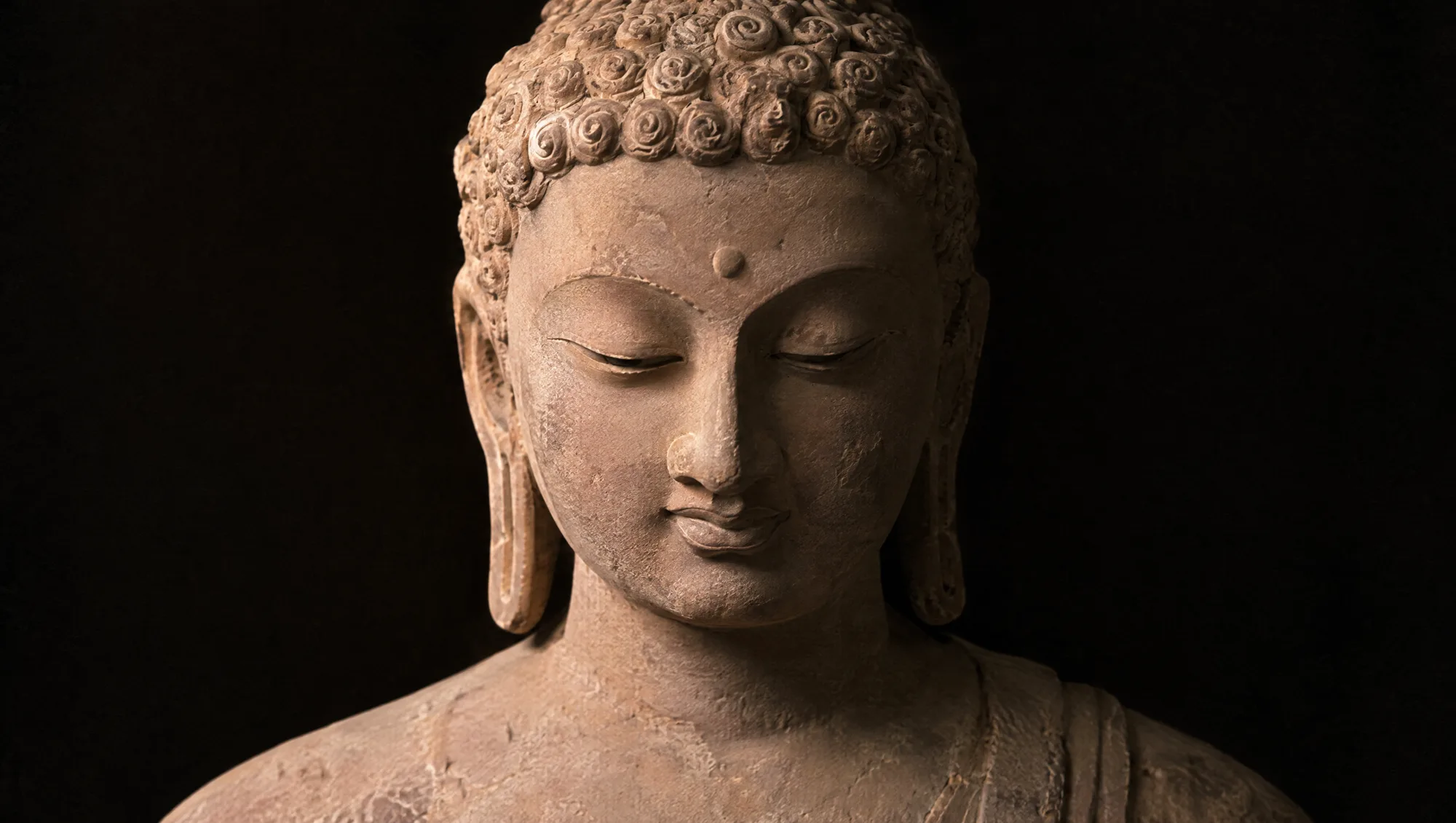 A Sarnath Gupta-period Buddha in pale pink sandstone with downcast eyes